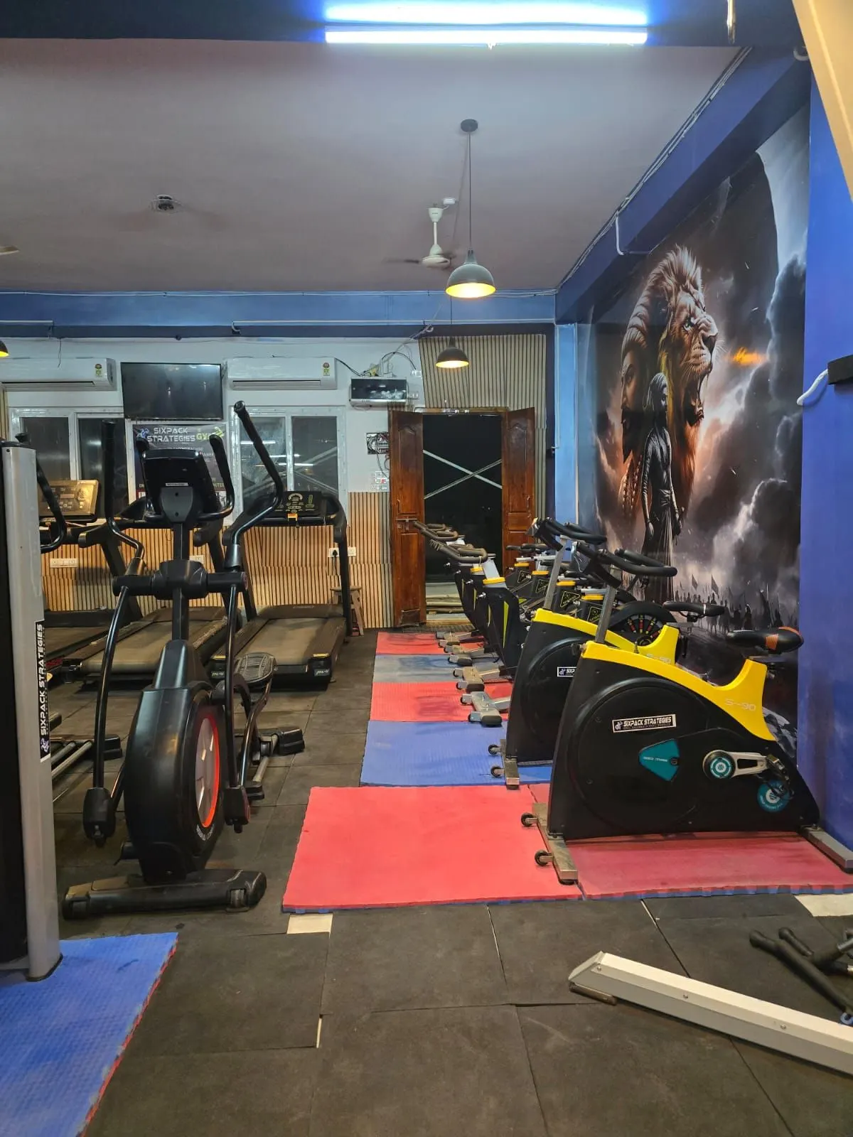 Cardio zone with treadmills, an elliptical machine, and spin bikes